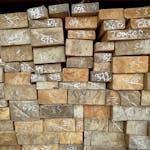 Close-up of numbered wooden planks stacked in a warehouse, showcasing timber storage and organization.